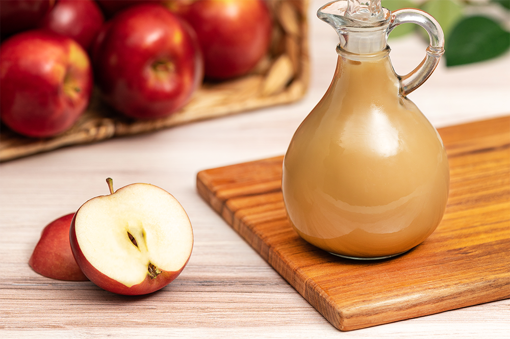 Infused Apple Cider Vinegar with fresh fruit on cutting board