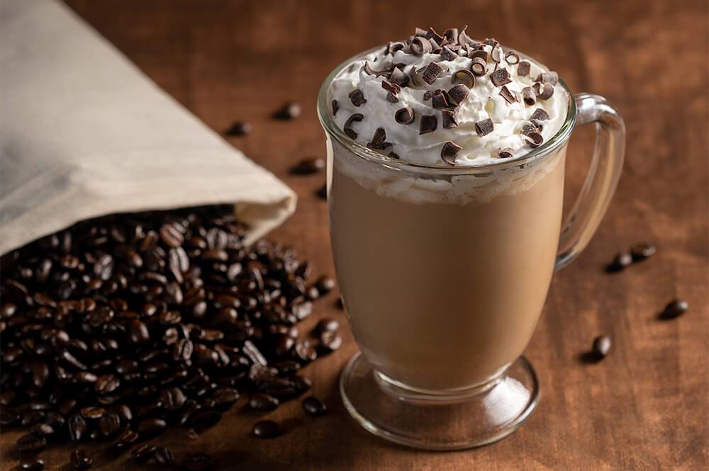 Magical Ice Cream Mochaccino with Fresh Espresso Beans Whipped Cream and Chocolate Shavings on Wood